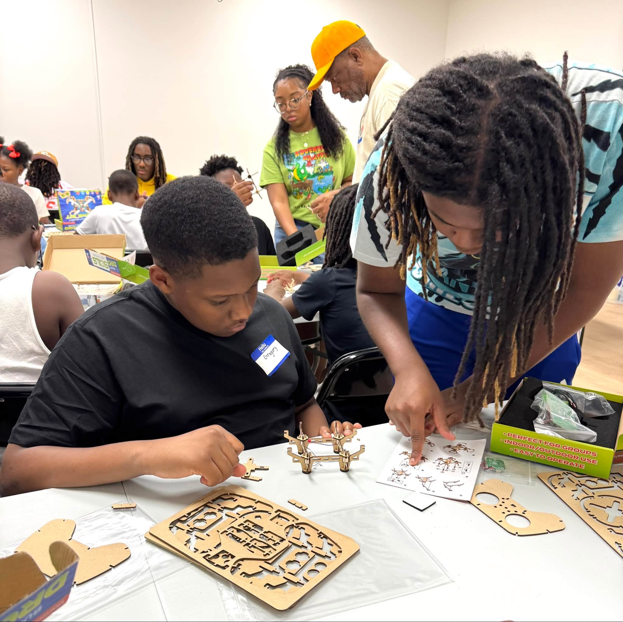 An older boy helping a younger boy assemble something with small pieces.